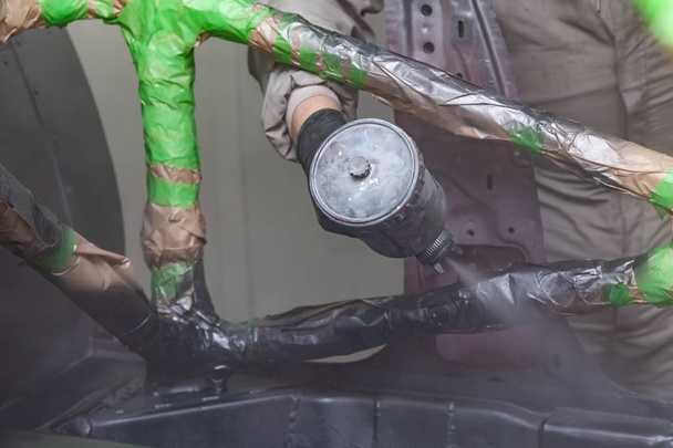 Un homme en combinaison de protection et un masque tient un flacon de pulvérisation dans
  - Photo, image