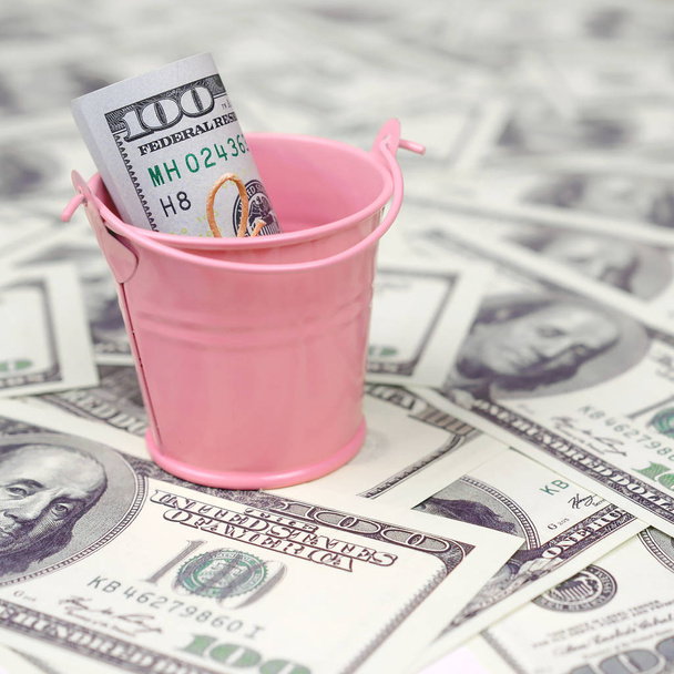 Egy köteg amerikai dollárt egy fém rózsaszín vödör egy sor dollár számlákat. A bőség és a többlet készpénz fogalma - Fotó, kép