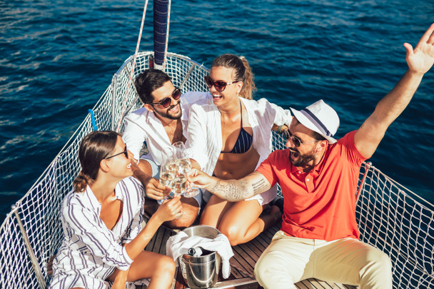 Посміхаючись друзям з келихами шампанського на яхті. Відпустка, tr
 - Фото, зображення
