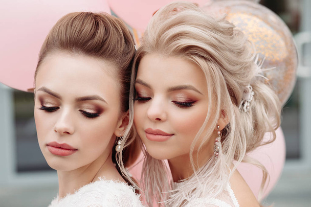 zwei hinreißende Models mit Make-up und Frisur in weiß. - Foto, Bild