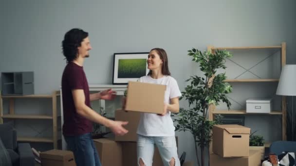 Man and woman bringing boxes with personal things moving in to new house - Filmati, video