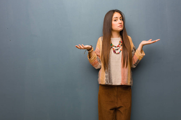Jonge hippie vrouw betwijfelen en schouderophalend schouders - Foto, afbeelding