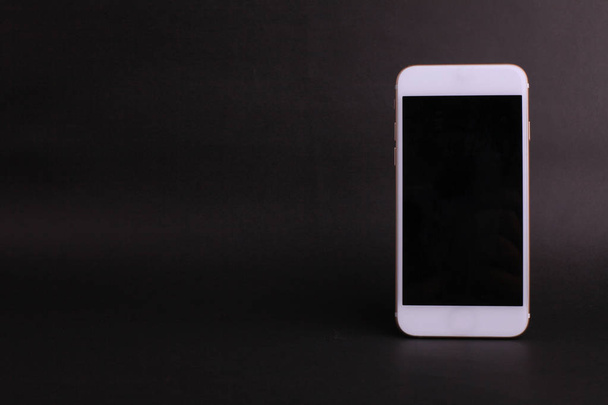 Белый цифровой смартфон на черном фоне
  - Фото, изображение