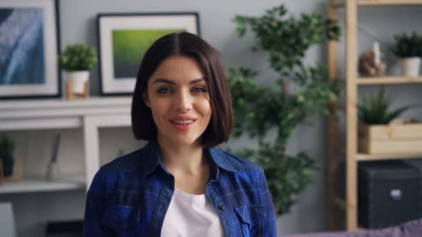 Slow motion portrait of beautiful woman in apartment smiling looking at camera - Záběry, video