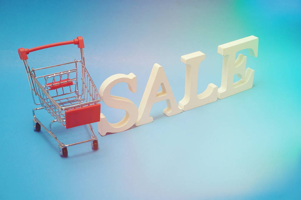 Sale and Mini Trolley Cart on blue background - Foto, imagen