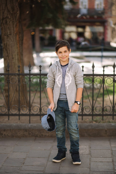 Cute boy walking in the city. Stylish teenage boy outside - Photo, image