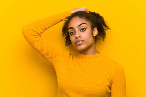 Young black woman closeup over an orange wall - Фото, изображение