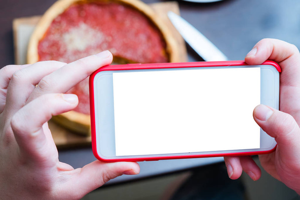 Vista dall'alto della pizza di Chicago. Donna mani scattare foto con smart phone di Chicago piatto profondo pizza italiana formaggio con salsa di pomodoro e manzo si incontrano all'interno. Schermo vuoto e vuoto
 - Foto, immagini