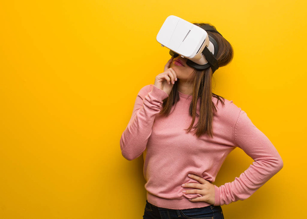Nuori söpö nainen yllään virtuaalitodellisuus googles epäillä ja sekoittaa
 - Valokuva, kuva