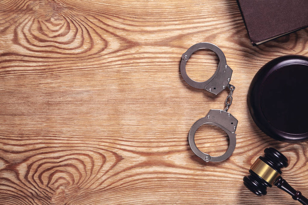 メタル手錠と早とちりは、木製の背景にあります。犯罪と  - 写真・画像