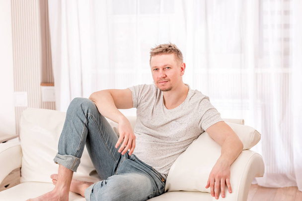 Man sitting at the sofa in bedroom - Foto, immagini