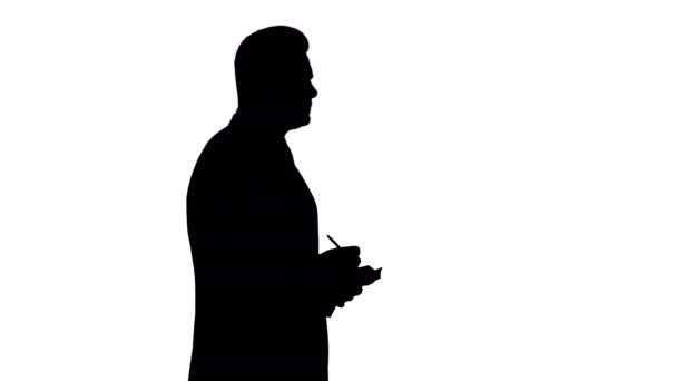 Silhouette Young positive caucasian businessman walking and making checklist. - Filmati, video