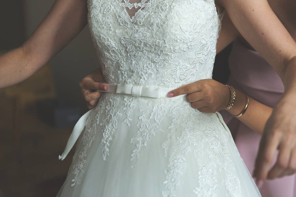 Невеста надевает платье
 - Фото, изображение