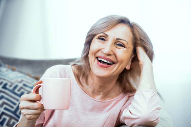 Happy mature woman with cup of tes in her hands - Fotoğraf, Görsel