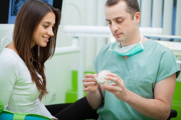 Dentist in dental office talking with female patient and preparing for treatment - Foto, Imagem