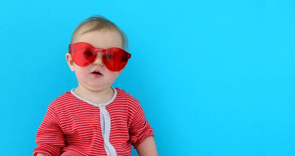Bébé mignon avec enfant en lunettes de soleil rouges
 - Photo, image