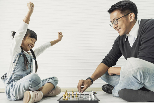 Szczęśliwy Asian rodzina gra szachy razem w Dom. - Zdjęcie, obraz