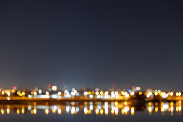 paysage urbain sombre avec bâtiments, lumières bokeh et rivière la nuit
 - Photo, image