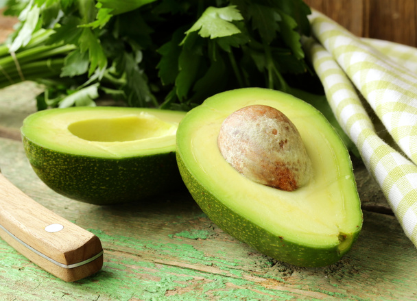 Ripe avocado cut in half on a wooden table - Photo, Image
