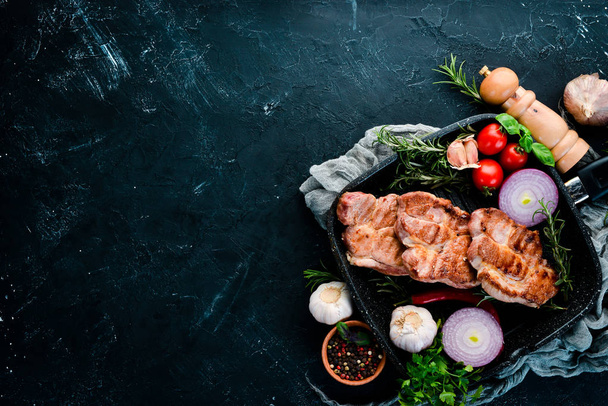 Steaks on the bone with rosemary. Grill, barbecue. On a black stone background. Top view. Free copy space. - Foto, imagen