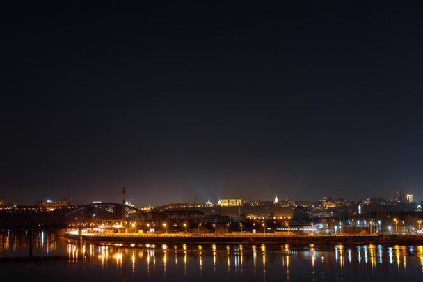 paesaggio urbano tranquillo con edifici illuminati e riflessione sul fiume di notte
 - Foto, immagini