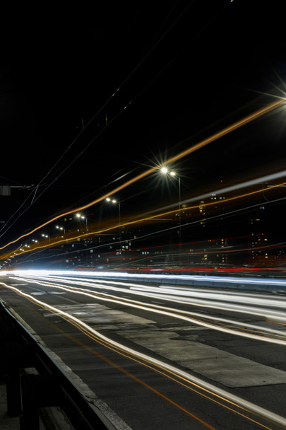 夜忙しい都市での道路上の明るい光の長時間露光 - 写真・画像
