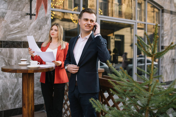 Handsome and Confident Businessman Using Laptop Computer and Technology Gadget Smartphone outdoor Discussing With Beautiful Business Partner .New Modern Business People Lifestyle. - Foto, Bild