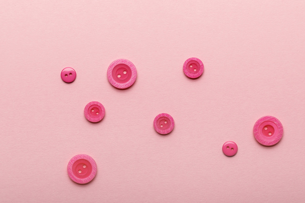 top view of round clothing buttons isolated on pink - Foto, Bild