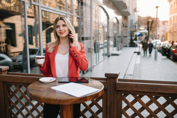 Businesswoman taking a coffee break and using smartphone. - Zdjęcie, obraz