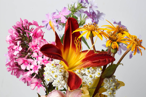 A fragment of bright bouquet gardeners with lilies and daisies. - Foto, Imagen
