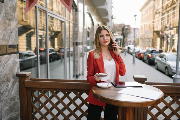 Businesswoman taking a coffee break and using smartphone. - 写真・画像