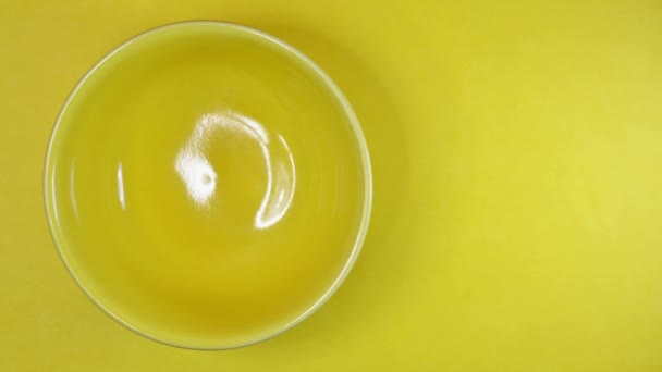 Zatrzymaj ruch żółtej miski z fasolą Pinto na kolorowym tle - Materiał filmowy, wideo