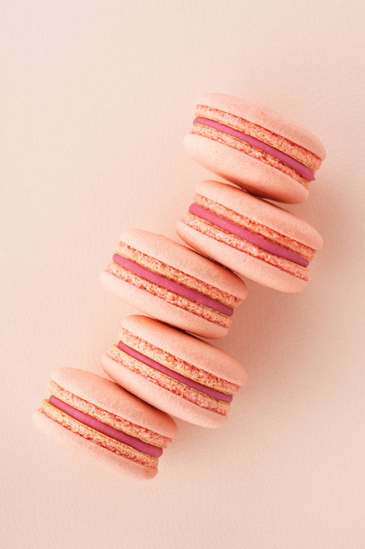 Row of pink macarons on same color background. - 写真・画像