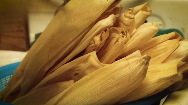 Γυναίκα που στραγγίζει φύλλα καλαμποκιού για tamales - Πλάνα, βίντεο