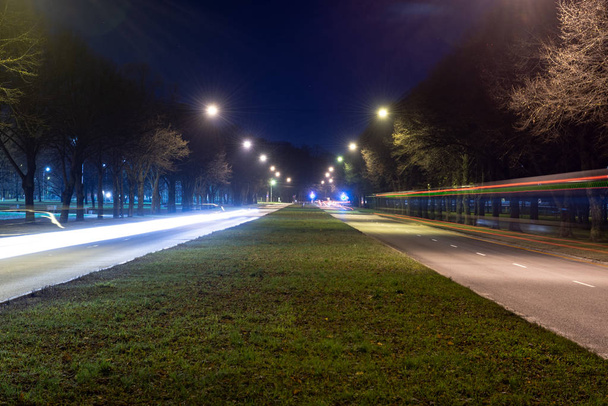 νυχτερινά φώτα του δρόμου στη Ρίγα της Λεττονίας. γραμμές από αυτοκίνητα και γέφυρες - Φωτογραφία, εικόνα