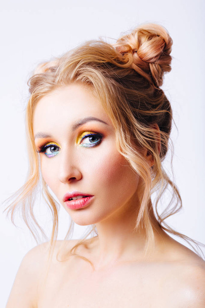 Young blonde girl with an original hairstyle and bright professional makeup - Fotografie, Obrázek