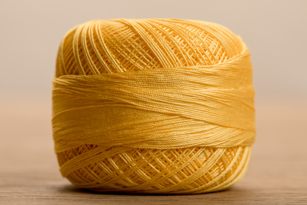vista de cerca de la bola de hilo de punto de algodón amarillo en beige
 - Foto, imagen