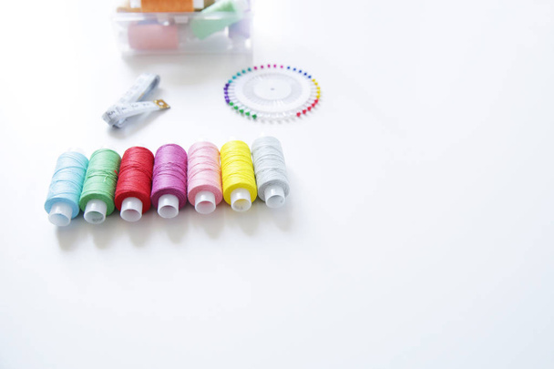  spools of colorful thread, meter and needles on white background - 写真・画像