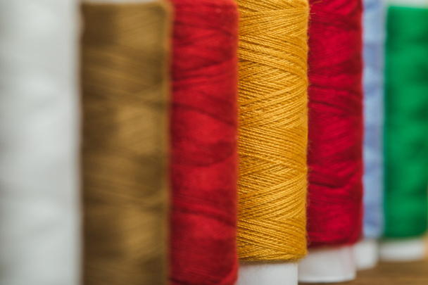 selective focus of colorful cotton thread coils in row with copy space - Fotó, kép