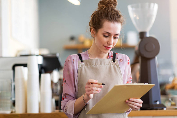 Woman working in coffee shop - Foto, afbeelding
