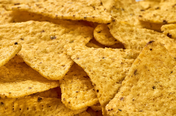 The background of yellow triangular corn nachos close-up - 写真・画像