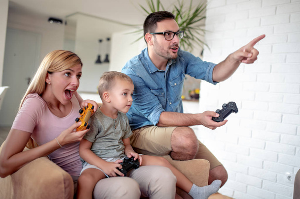 幸せな家族は自宅でビデオゲームをプレイし、一緒に楽しみます. - 写真・画像