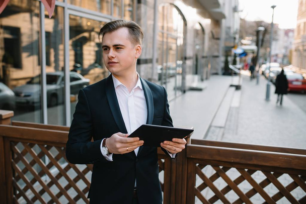 Young business man with tablet near of modern building. - Фото, изображение