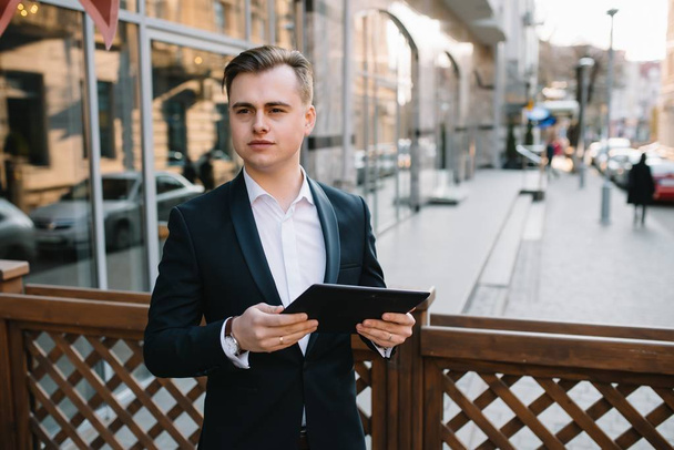 Young business man with tablet near of modern building. - Φωτογραφία, εικόνα