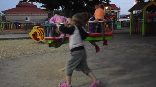 Tres niños felices se divierten en el parque infantil - Imágenes, Vídeo