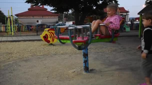 Niños pequeños jugando en el patio de recreo en verano - Imágenes, Vídeo