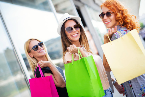 Happiness, friends, fun and shopping concept-smiling young women with shopping bags - Photo, Image
