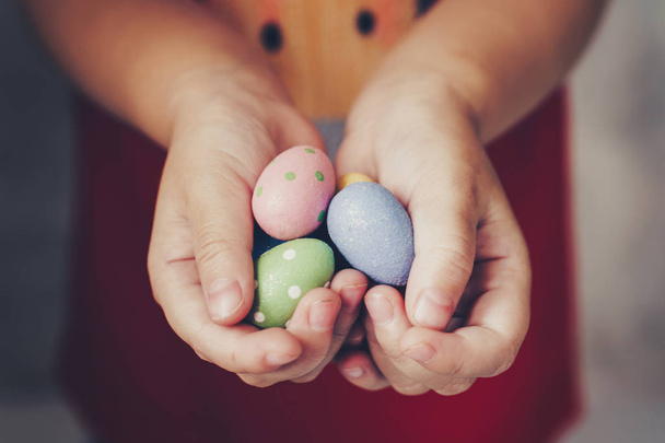Pieni tyttö kädet tilalla pääsiäismunia maalattu väri kädessä
 - Valokuva, kuva
