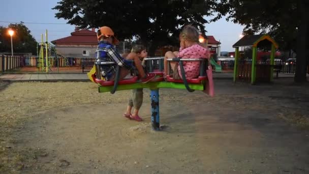Tres niños felices se divierten en el parque infantil - Imágenes, Vídeo