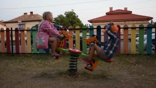Feliz niño y niña divirtiéndose en el patio de recreo - Imágenes, Vídeo